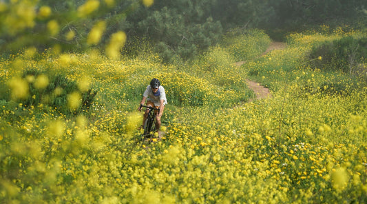 man riding bike through field